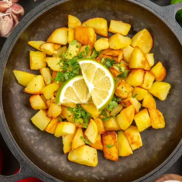 fried potatoes in a pan with lemons