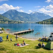 Camping am Tegernsee Stellplätze mit Wohnmobilen am Seeufer vor Bergkulisse